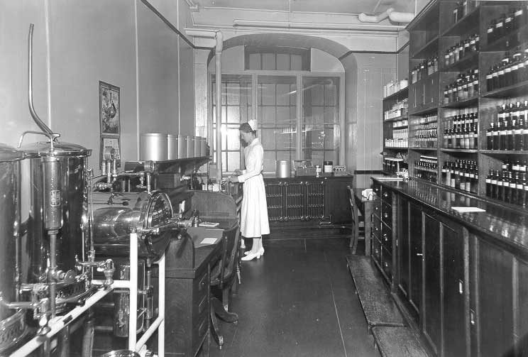 Medical Department clinic in Montreal, nurse in pharmacy with sterilization equipment on left