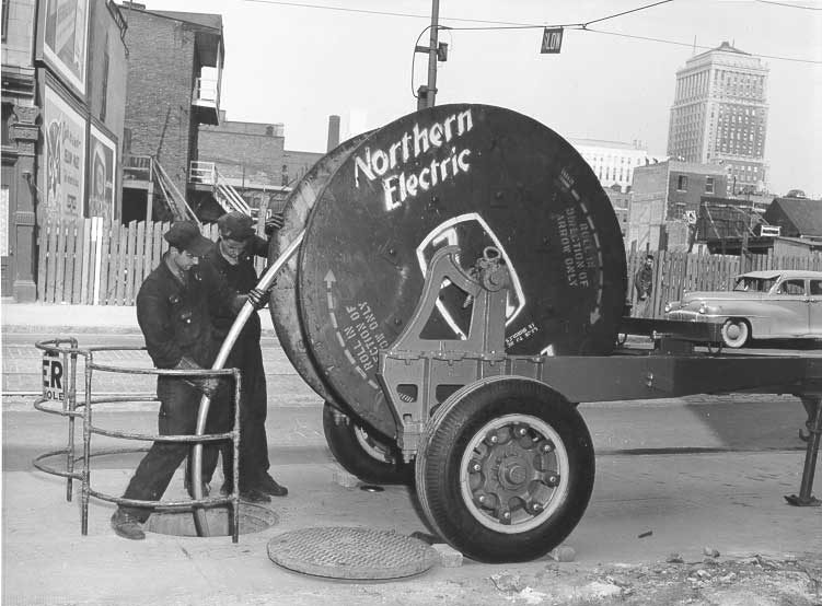 Workers lay cable in underground conduits