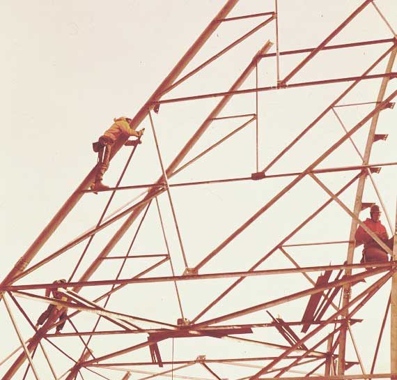 Men assemble parabolic antenna framework