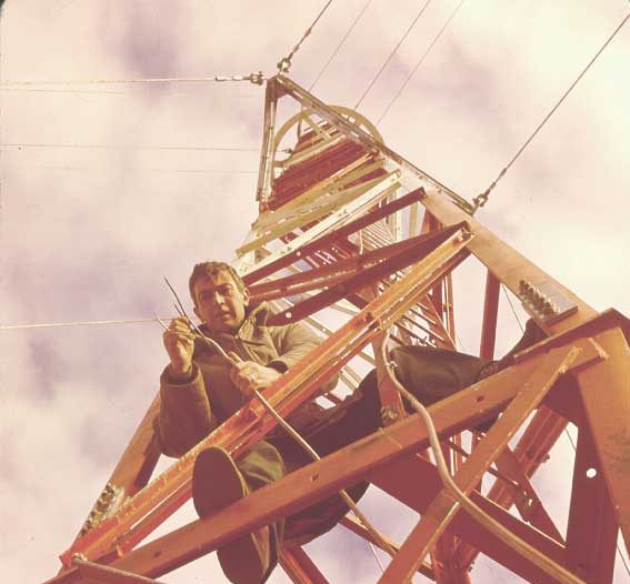 Engineer checks wiring on microwave radio tower