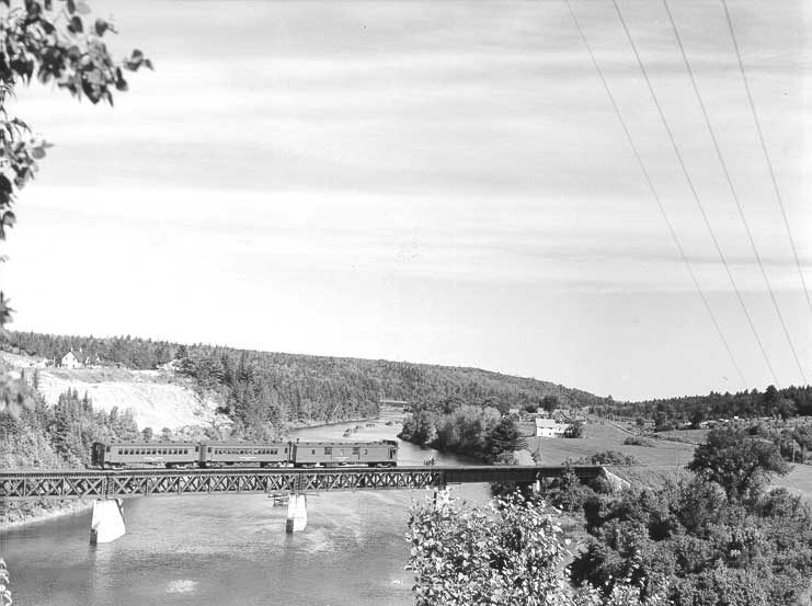 An early diesel-electric car with coaches in tow, crossing the Nashwaah River