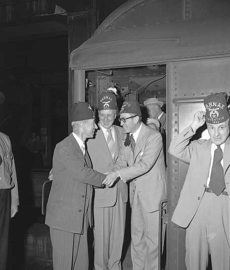 Actor Harold Lloyd, wearing his trademark glasses, greets fellow shriners as North America's High Potentate of the Shriners