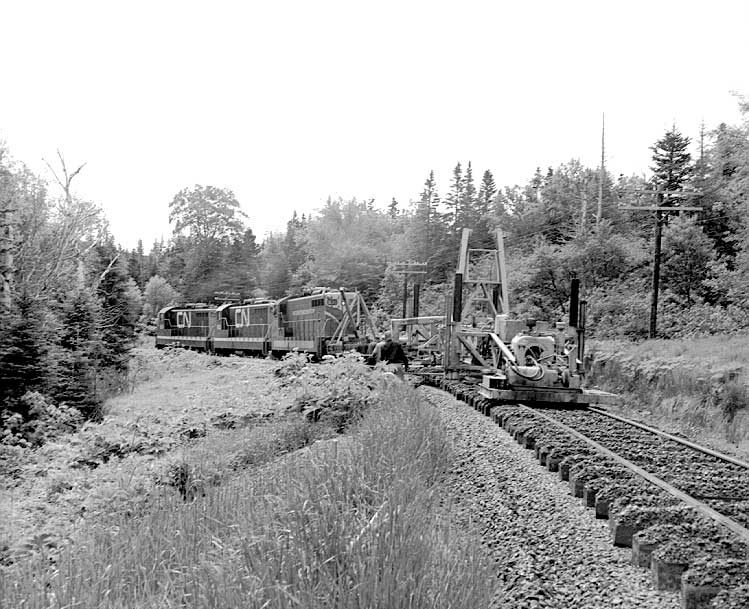 A track maintenance train begins tamping the ballast
