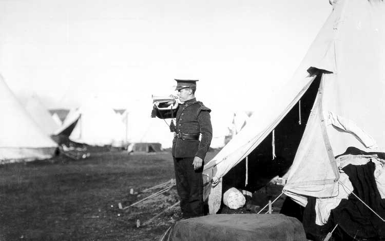 A bugler sounding a duty call at a WWI training camp