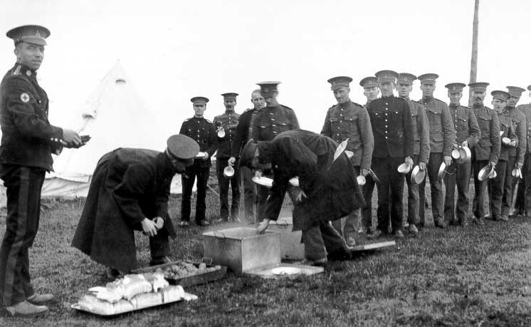 Soldiers line up for their meal at a WWI training camp