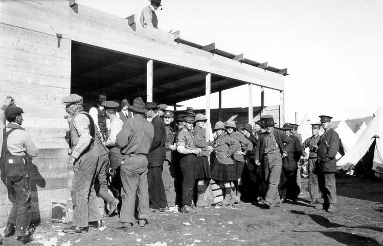 Soldiers standing around a building under construction at a WWI training camp