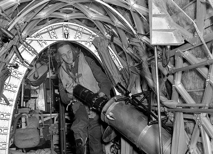 An RCAF bomber crew member releasing a flare to light up a target for other bombers or photography