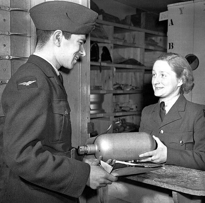 An airman receives a fire extinguisher from the equipment assistant, a member of the RCAFWD