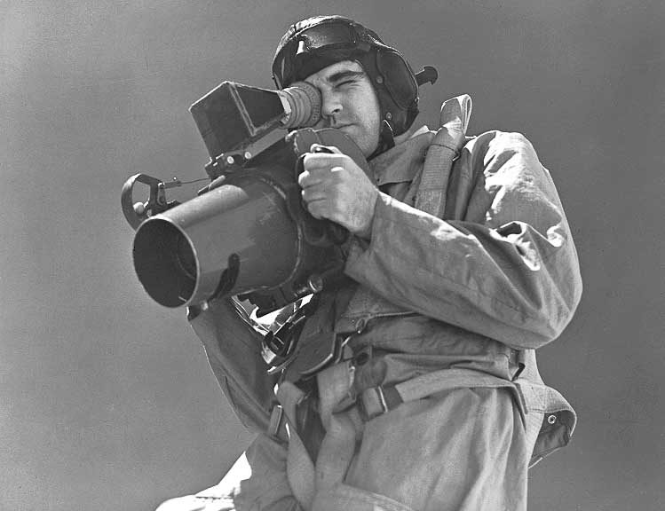 An RCAF aerial photographer checks over his camera before flight
