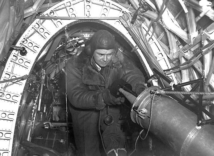 An Observer in a Wellington bomber inserts a flare into the flare chute of his aircraft