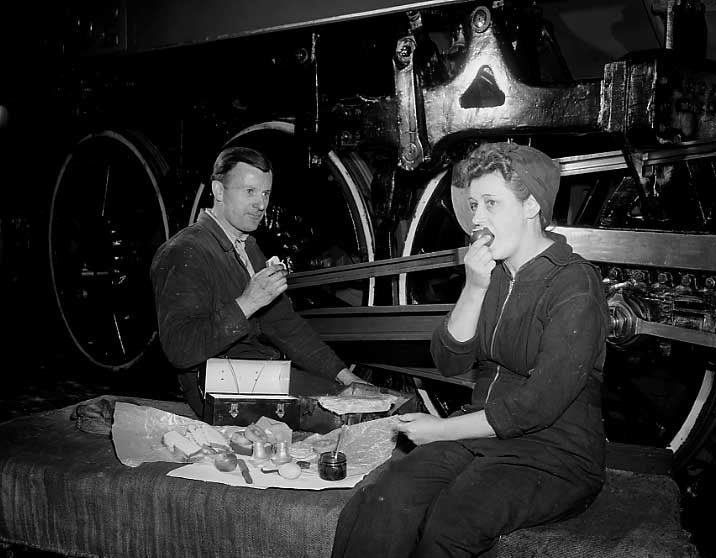 Mr. and Mrs. McBride, boilermaker helper and engine cleaner respectively, share a lunch at work