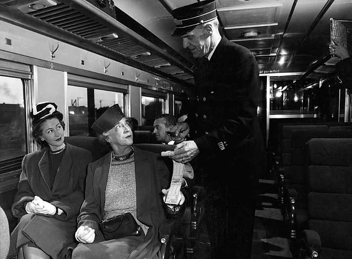A Canadian National Railways passenger service conductor receives tickets
