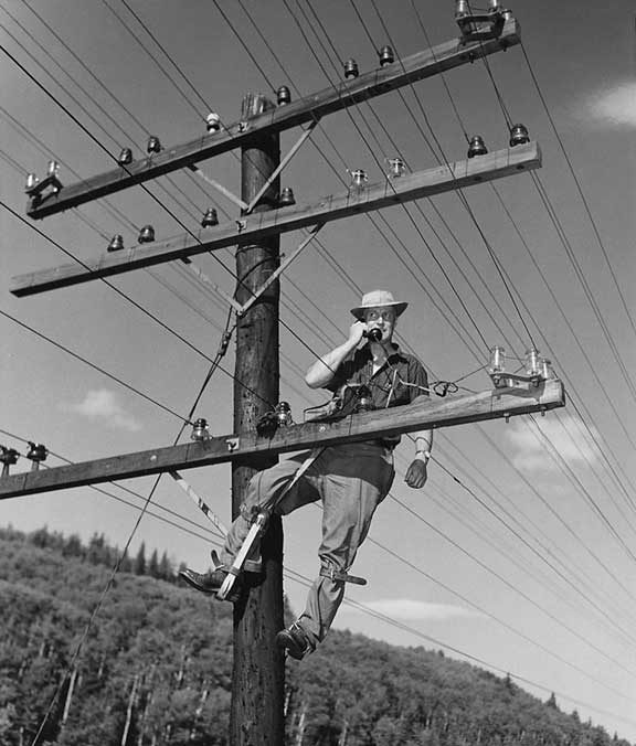 A signals supervisor taps a line with a telephone