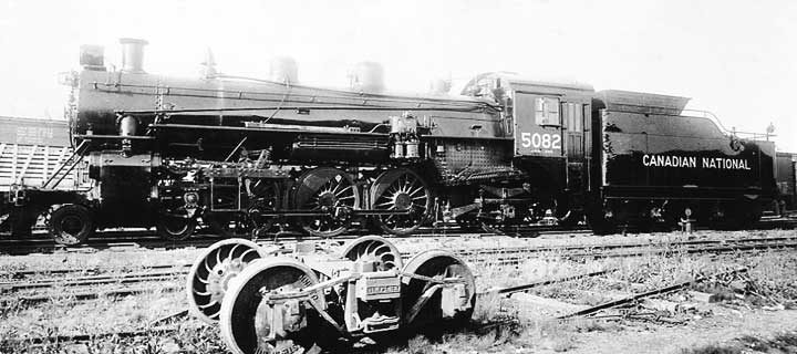 CN steam locomotive 5082 beside Simplex arch bar freight truck