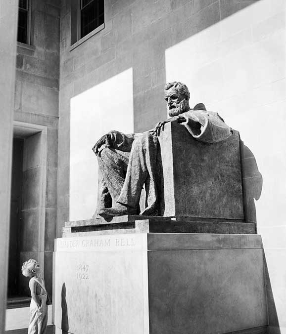 A little boy admires the Alexander Graham Bell monument in front of the Bell Telephone Company building