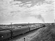 Pullman passenger coaches are hauled across the Canadian prairies by a Canadian National Railways steam locomotive