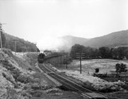 A Canadian National Railways passenger train steams through a valley in Quebec
