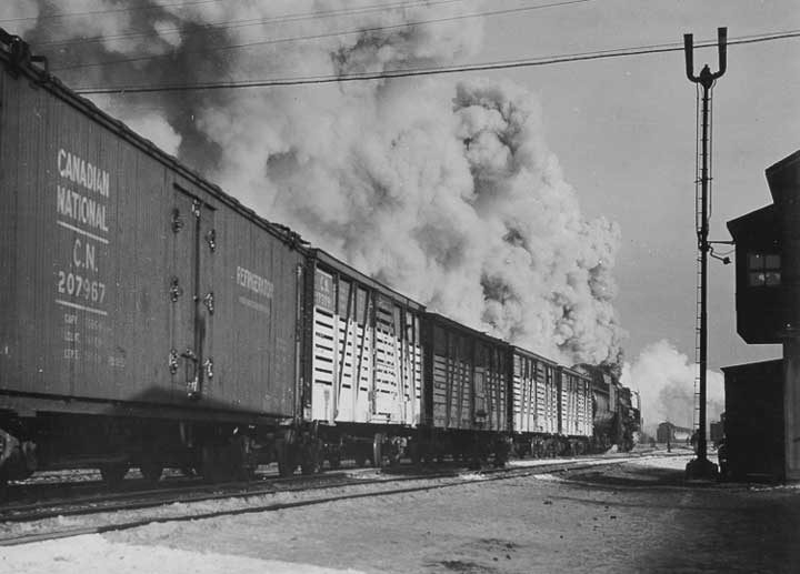 A Canadian National Railways freight train steams through a railway station at Turcot