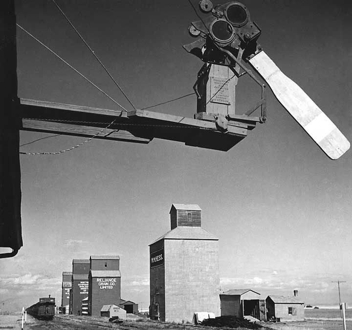 An automatic block signal and a row of grain elevators in Western Canada