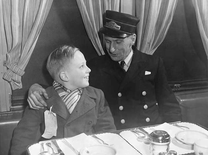 A Canadian National Railways conductor reassures a young immigrant