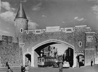 Street railway cars and automobiles passing through St. John's Gate