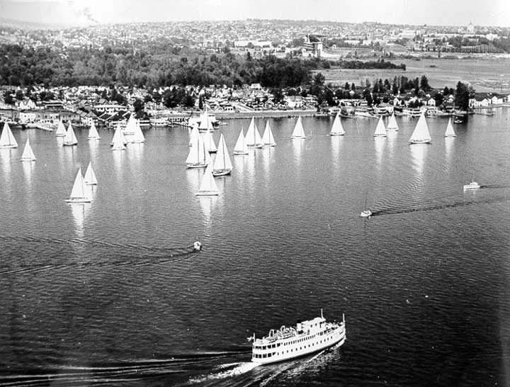 An excursion boat passes a fleet of sailing boats on Lake Washington