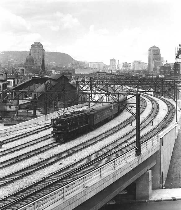 Electric locomotive hauls passenger train over Wellington Street