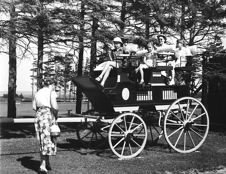 Visitors pose for the camera aboard a stage coach on display in a park