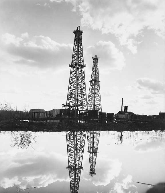 A view of the British Petroleum oil wells showing the crude oil pool in the foreground.