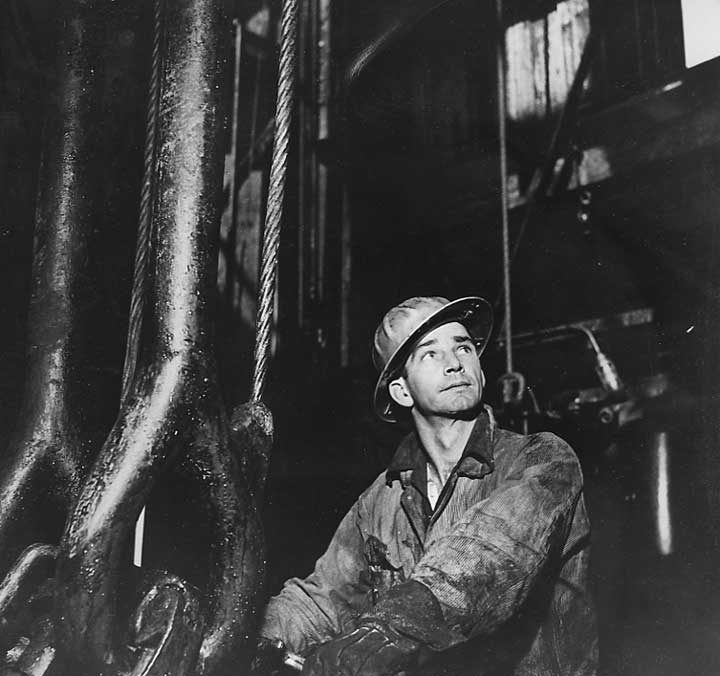 A petroleum worker operating the heavy equipment of an oil drilling rig