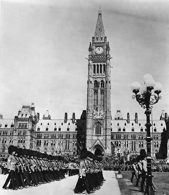 A view of a military ceremony before the Parliament Buildings in honour of their Majesties King George VI and Queen Elizabeth during the 1939 Royal Tour of Canada