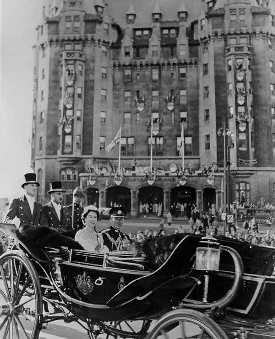 Queen Elizabeth and Prince Philip are carried past the Château Laurier in the royal coach during their visit to Ottawa to open the 23rd Canadian Parliament