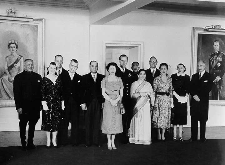 Queen Elizabeth and Prince Philip pose with diplomatic personnel at an embassy function during the 1957 Royal Visit