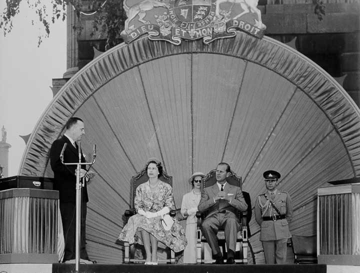 Queen Elizabeth and Prince Philip listen attentively to a presentation during the 1959 Royal Tour of Canada