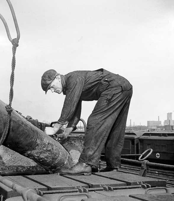 A Canadian National Railway lineman filling the water tank of a steam locomotive