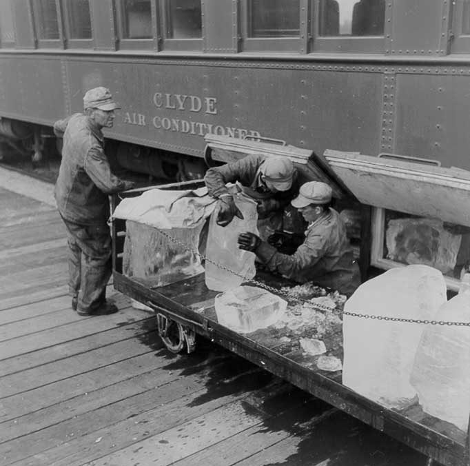 Loading blocks of ice into the air-conditioning unit of a Canadian National Railways passenger coach