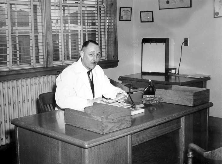 Dr. R.F. Brown behind his desk at the Moncton CN medical clinic