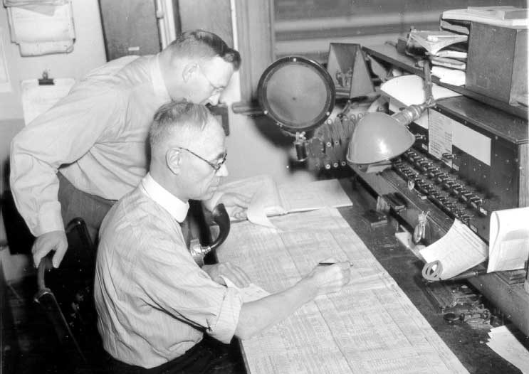 CN employees examining train dispatch sheets