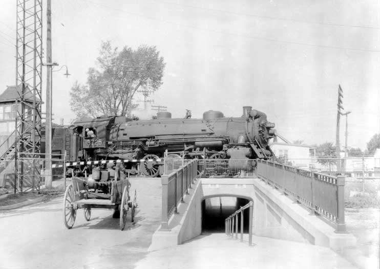 Steam locomotive 3725 traveling over a pedestrian underpass