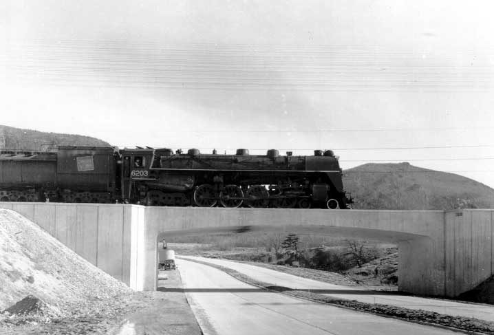 Steam locomotive #6203 traveling on overpass
