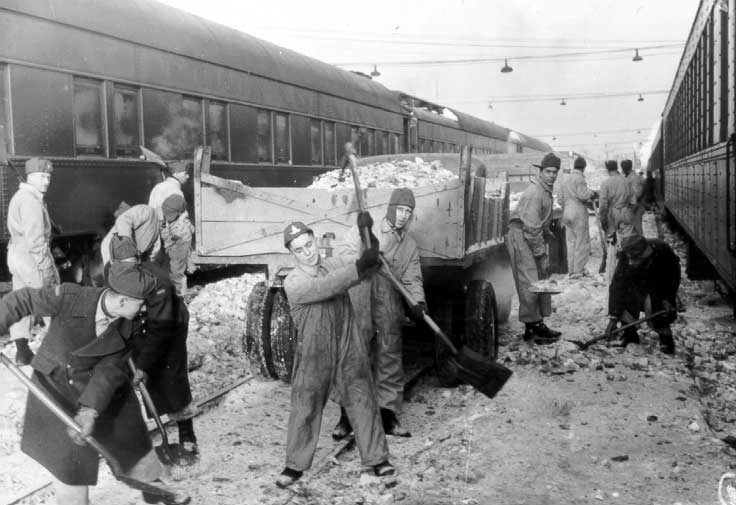 Soldiers clearing snow off tracks
