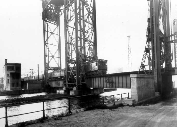 Electric passanger train traveling over lift bridge