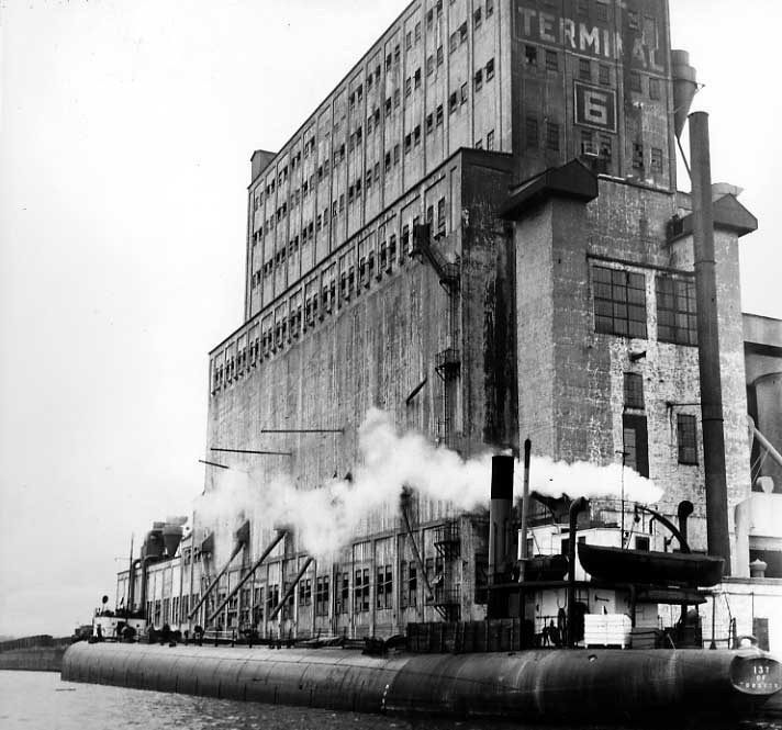 Whaleback freighter loading grain at pool elevator no. 6