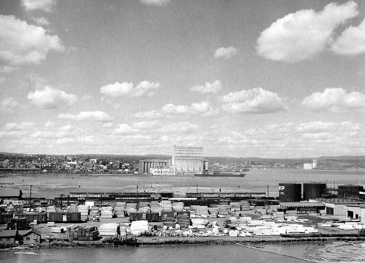 Aerial view of lumberyard, grain elevator and city of Port Arthur