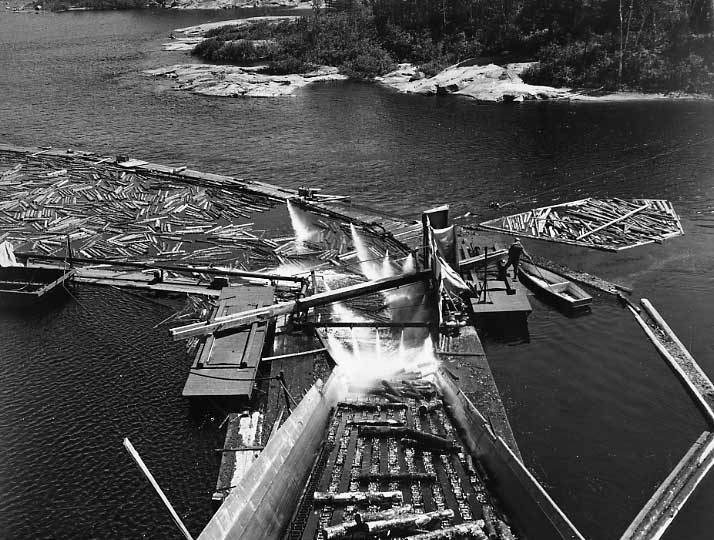 Water jets pushing logs onto the conveyor, St. Lawrence Corp. Ltd., Quebec