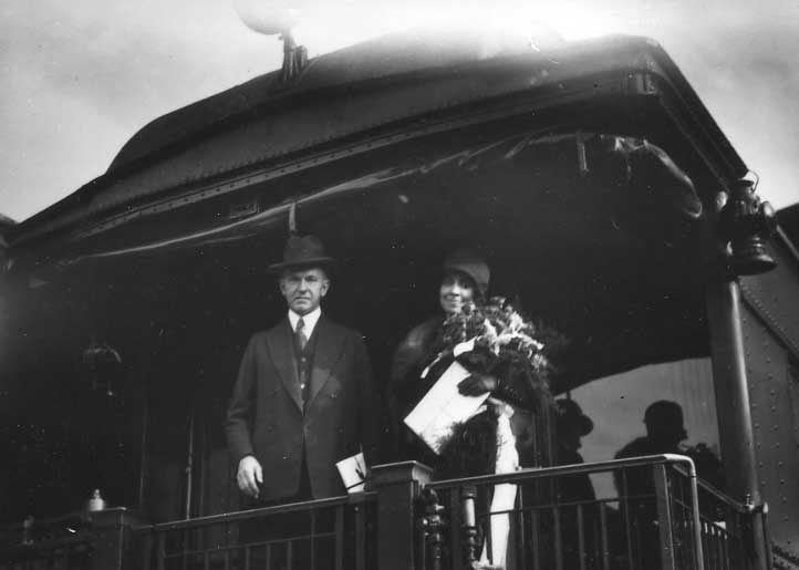 United States President and Mrs. Calvin Coolidge standing on the open platform of a business car