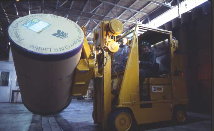 Loading QNS Paper Co. Ltd. Newsprint rolls into boxcars.
