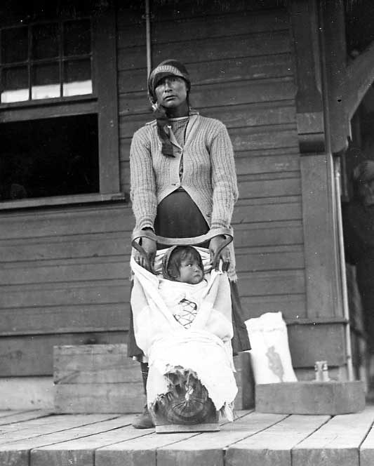 Aboriginal woman with child on porch