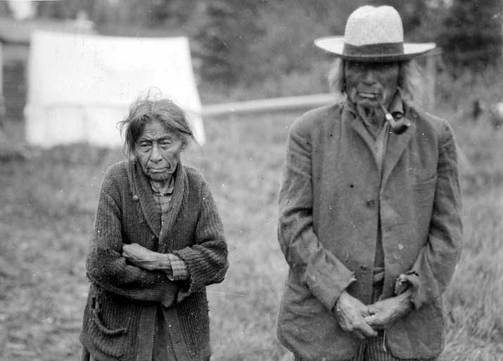 Elderly Ojibwa husband and wife in front of prospector-type tent