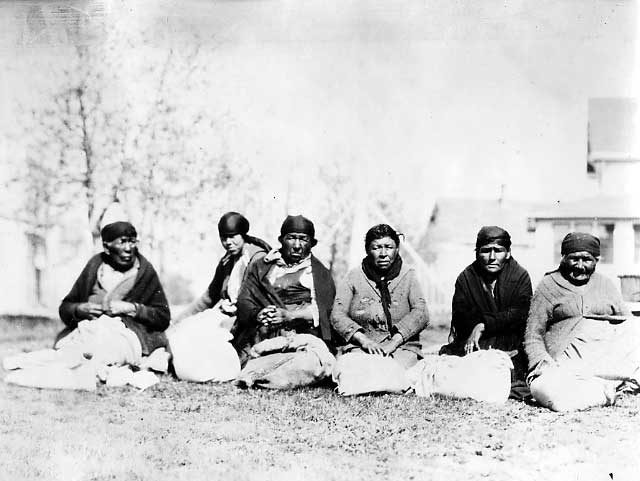Seven Northern Aboriginal women sitting on the grass